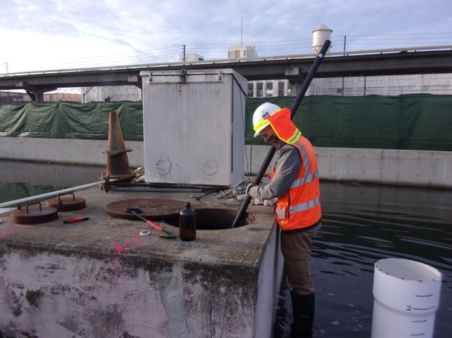 An engineer collects a sample.